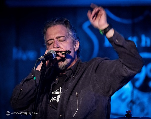 Instructor Michael Wilde on Stage Playing Harmonica 