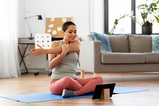 woman exercising in front of tablet computer